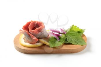 Skinless fish fillet (rolled up) with slices of lemon and onion