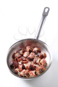 Bacon wrapped prunes in a saucepan - studio