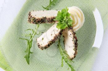 Slices of herb coated goat cheese - closeup