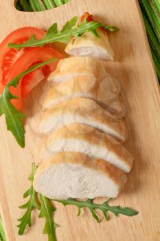 Sliced chicken breast fillet on a cutting board
