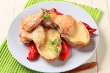 Chicken wings with baked potato and red peppers