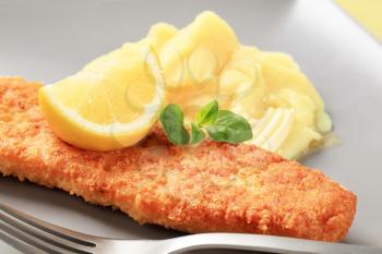 Fried battered fish fillet with potato puree and lemon