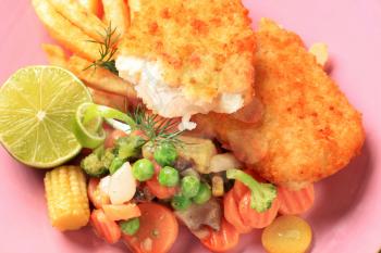 Fried breaded fish fillets with  mixed vegetables and French fries