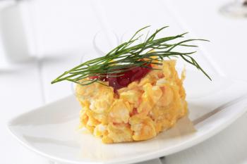 Scrambled eggs topped with fruit preserve and dill
