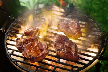 Grilling marinated meat on a charcoal grill