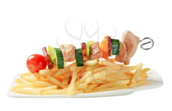 Pork and vegetable skewer with French fries