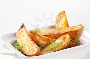 Roasted potato wedges garnished with fresh dill