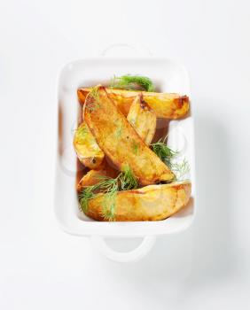 Roasted potato wedges garnished with fresh dill