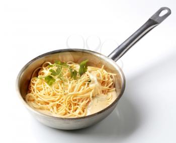 Spaghetti and cream sauce in a saucepan