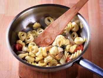 Preparing pasta dish in a saucepan - detail