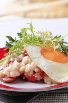 White beans with sausage and fried egg - detail