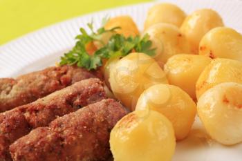 Pan roasted minced meat kebabs and potatoes