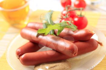 Breakfast of boiled sausages with mustard and tomatoes