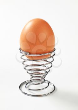 Brown egg in modern spiral metal egg cup