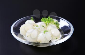 Pickled pearl onions on a glass plate