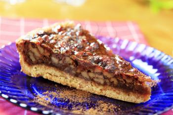 Piece of nut tart dusted with cocoa powder