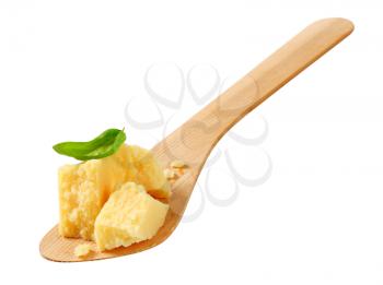 Pieces of Parmesan cheese on wooden spatula