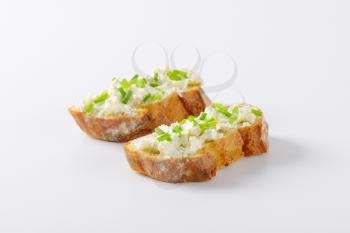 Crunchy baguette slices with cheese spread and chives