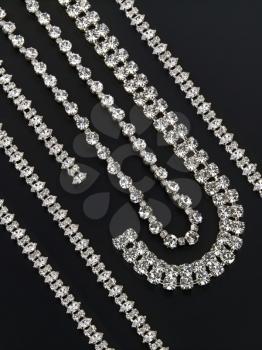 Display of silver necklaces and bracelets with shiny gemstones
