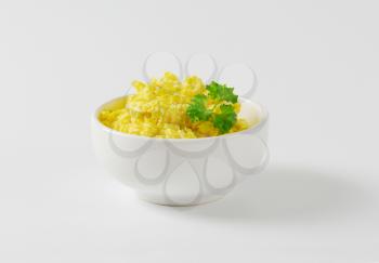 Scrambled eggs in white bowl