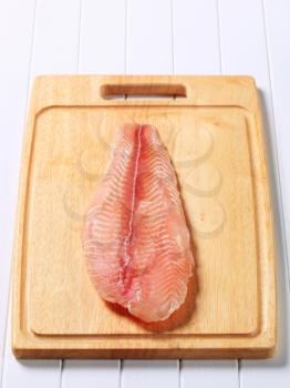Frozen catfish fillet on cutting board