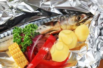 Raw mackerel and vegetables on aluminum foil