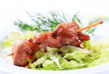 Pork skewer with barbecue sauce and lettuce