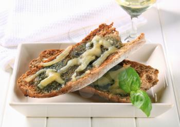 Toasted pesto bread topped with cheese