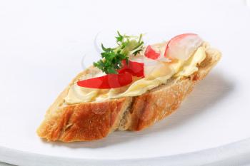 Slice of baguette with butter, radish and cress