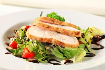 Slices of chicken breast fillet with green salad