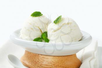 Scoops of white creamy ice cream in a dessert bowl