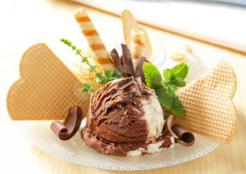 Scoops of ice cream garnished with wafers and chocolate curls