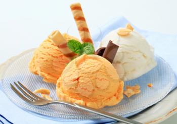 Scoops of ice cream garnished with wafer rolls