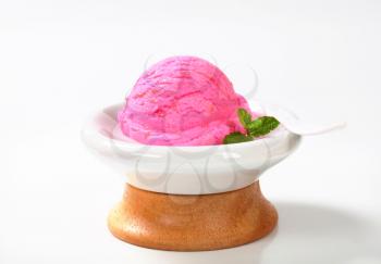 Scoop of pink ice cream in a dessert bowl