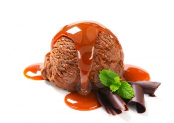 Scoop of fudge ice cream with caramel syrup and chocolaate curls