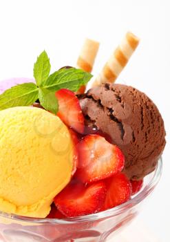Ice cream sundae with strawberries and wafer sticks,