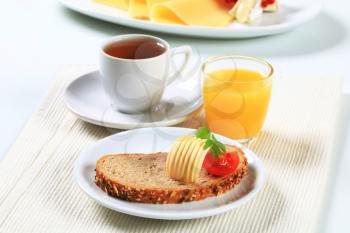 Bread with butter, cup of tea and orange juice - still life