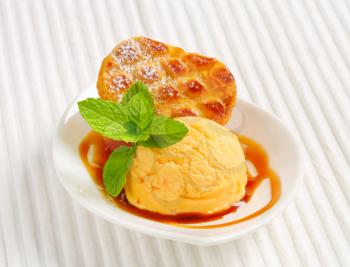 Small Dutch oval-shaped cake (Roomboter kano) with ice cream and caramel syrup