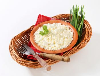 Bowl of Bryndza cheese and fresh chives in wicker basket