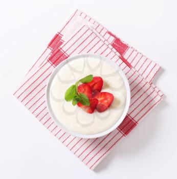 Bowl of semolina pudding with fresh strawberries