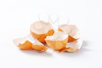 Empty brown egg shells on white background