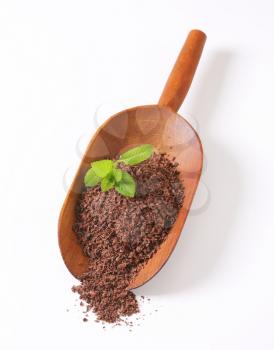 Grated chocolate on wooden scoop