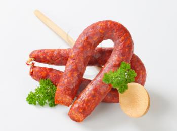 Spicy dry sausages and wooden  spoon