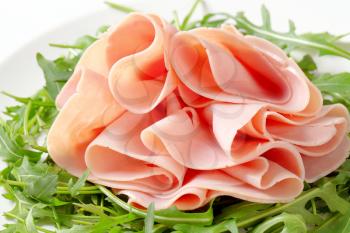 Sliced ham on nest of rocket salad