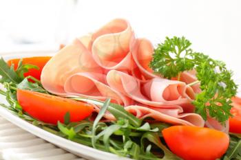 Sliced ham on nest of rocket salad