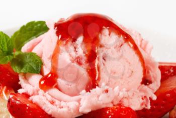 Scoop of pink ice cream with fresh strawberries