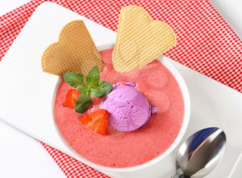 Chilled strawberry soup with scoop of ice cream and wafers