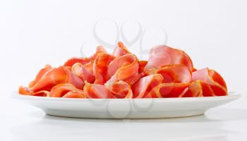 Thin slices of smoked pork arranged on plate