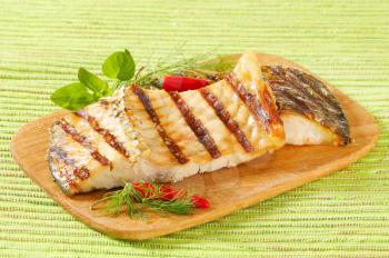 Grilled carp fillets on cutting board