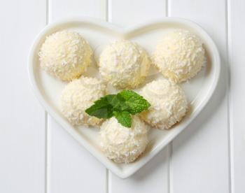 Coconut snowball truffles on heart-shaped plate